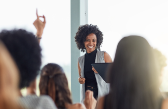 Persona liderando la Asamblea General Ordinaria frente a los asistentes.